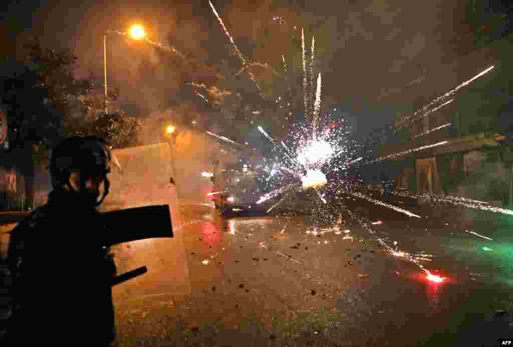Supporters of Lebanon's Shi'ite Hezbollah and Amal groups hurl fireworks at security forces in central Beirut.