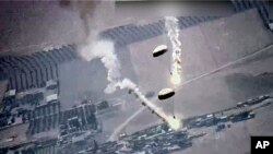 Na fotografiji načinjenoj iz video snimka Američkih vaduhoplovnih snaga, vide se baklje sa padobranima koje je, prema navodima Američkih vaduhoplovnih snaga ispustio ruski avion, 5. jula 2023. u Siriji.