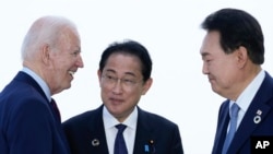 FILE - President Joe Biden talks with Japan's Prime Minister Fumio Kishida and South Korean President Yoon Suk Yeol, right, ahead of a trilateral meeting on the sidelines of the G7 Summit in Hiroshima, Japan, May 21, 2023. 