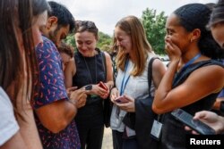 Empleados del Senado de EEUU reaccionan al ver en un video de prensa cómo eran evacuados con supervisión de la policía el 2 de agosto de 2023, tras una llamada no confirmada de la existencia de un tirador activo en el edificio federal.