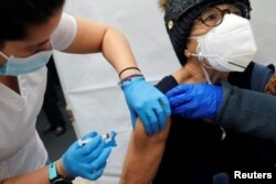 Un trabajador de la salud administra una inyección de la vacuna Moderna COVID-19 a una mujer en un sitio de vacunación emergente operado por SOMOS Community Care durante la pandemia de la enfermedad por coronavirus en Manhattan, en Nueva York en 2021. (Foto: Reuters)