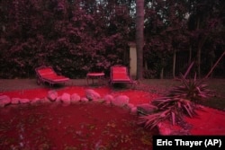 Fire retardant covers a backyard in Mandeville Canyon during the Palisades Fire, Saturday, Jan. 11, 2025, in Los Angeles