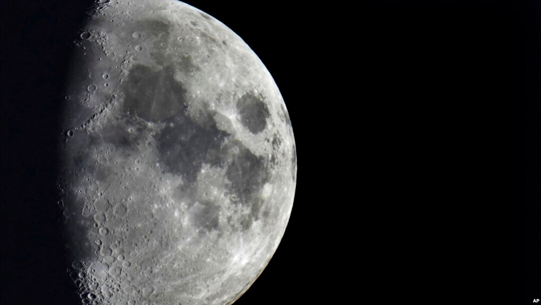 FILE - Impact craters cover the surface of the moon, seen from Berlin, Germany, Jan. 11, 2022. The moon is in line to be hit March 4 hit by 3 tons of space junk, a leftover rocket part.