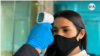 Un oficial de seguridad mide la temperatura a una trabajadora nicaragüense. Foto Houston Castillo, VOA.