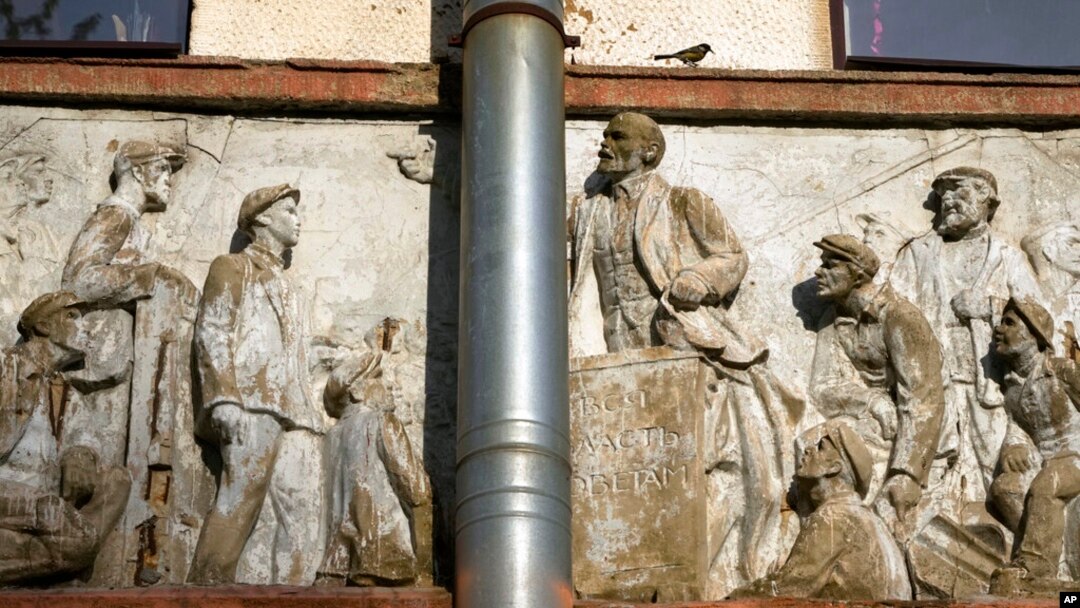A bird sits at a bas-relief on an old Soviet-era clubhouse, depicting Soviet Union founder Vladimir Lenin speaking to workers in St. Petersburg, Russia, May 25, 2022.