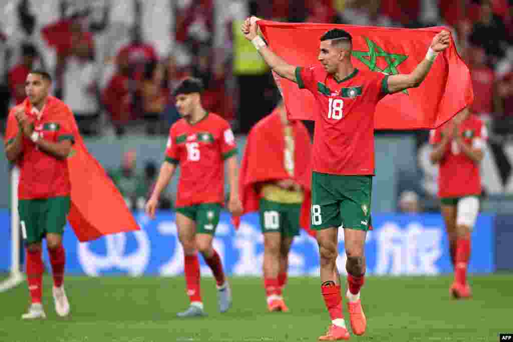 Jogador Jawad El Yamiq celebra com a bandeira de Marrocos. 