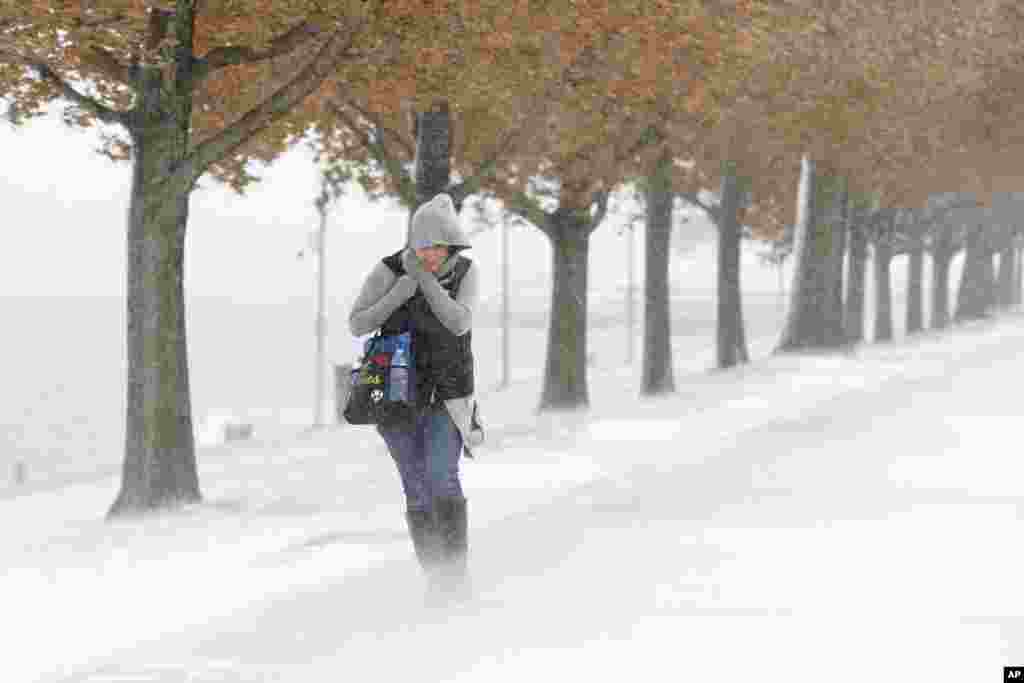 A woman braces the stiff wind and blowing snow off Lake Michigan, Nov. 11, 2019, in Chicago, Illinois.