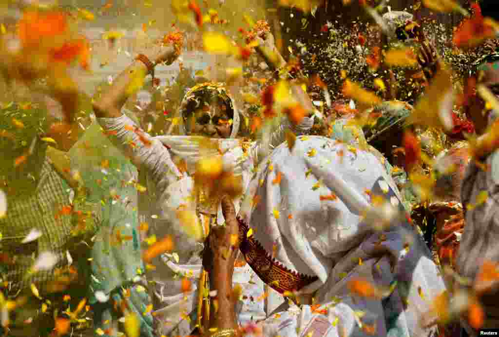 Viúvas dançam enquanto participam nas celebrações do Holi no interior de um templo em Vrindavan, no estado de Uttar Pradesh, no norte da Índia.