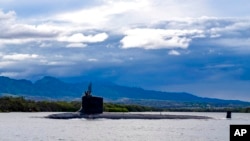 FILE - In this photo provided by U.S. Navy, a submarine departs Joint Base Pearl Harbor-Hickam, Sept. 1, 2021. 