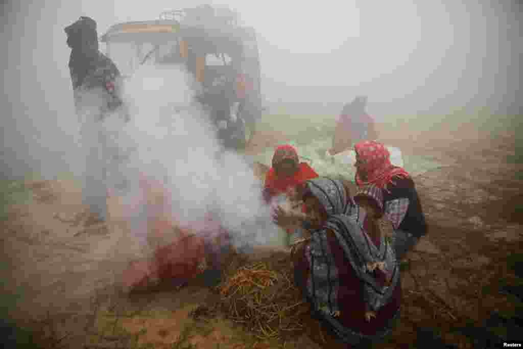Devotees gather near the fire to keep themselves warm during the "Gadhimai Mela" festival held in Bariyarpur, Nepal. The festival, renowned for its large number of animal sacrifices, is held every five years at the Gadhimai Temple.
