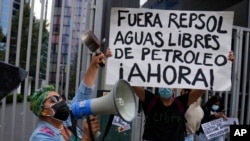 Manifestante sostiene una pancarta que dice en español "Fuera Repsol aguas libres de petróleo Ahora!" durante una protesta frente a la oficina de Repsol en Lima, Perú, el jueves 27 de enero de 2022.