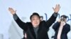 윤석열 한국 국민의힘 대통령 후보가 8일 서울에서 열린 유세에서 지지자들의 환호에 답하고 있다.