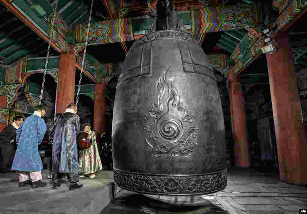 Participantes tocaram um enorme sino para dar as boas-vindas ao Dia de Ano Novo de 2025, durante as celebrações após a meia-noite no pavilhão Bosingak, no centro de Seul, Coreia do Sul, no dia 1 de janeiro de 2025.