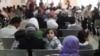 FILE - Syrian refugee families wait to be registered with the UNHCR services, during the Australian Foreign Minister Julie Bishop's visit to the compound, to meet with the UNHCR representative to Jordan, Andrew Harper, regarding the Syrian refugee situation, in Amman, Jordan, April 21, 2014.