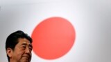 រូបឯកសារ៖ លោក Shinzo Abe អតីតនាយករដ្ឋមន្ត្រីជប៉ុន ឈរនៅមុខទង់ជាតិជប៉ុន ក្រោយពីចូលរួមសមាជបក្សប្រជាធិបេតយ្យសេរីនិយម (LDP) នៅទីក្រុងតូក្យូ ប្រទេសជប៉ុន កាលពីថ្ងៃទី ៥ ខែមីនា ឆ្នាំ ២០១៧។