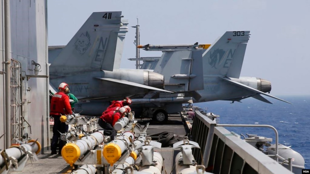 美國海軍卡爾·文森航空母艦上的人員在F-18戰機例行出航前準備為飛機加裝導彈。（2017年3月3日）