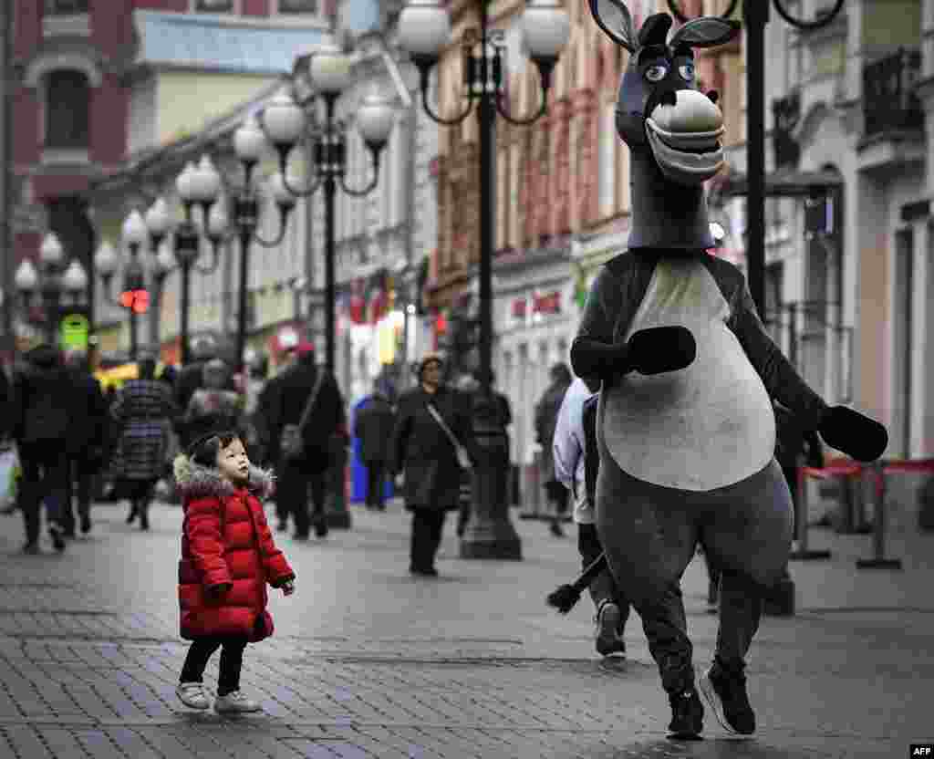 A young girl looks at an animator in downtown Moscow, Russia.