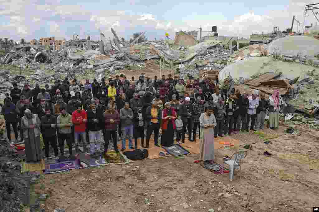 Palestinians perform Friday prayers near the ruins of a mosque destroyed by Israeli airstrikes in Khan Younis, Gaza Strip. (AP Photo/Jehad Alshrafi)