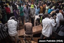 The casket containing the body of Duku Evans, who was killed November 3 amid fighting between government troops and rebels in Logo displaced persons camp in Kajo Keji, South Sudan, is lowered into a grave on the Ugandan border, Nov. 5, 2017.