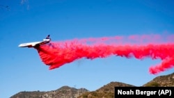 An air tanker drops retardant while working to contain the Eaton Fire in Altadena, Calif., Monday, Jan. 13, 2025.