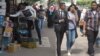 Young Egyptians pass by a kiosk near Ain Shams University in Cairo, April 21, 2016. College students in Egypt worry about jobs, as the country has long had more college graduates than jobs in desired professions. (H. Elrasam/VOA)