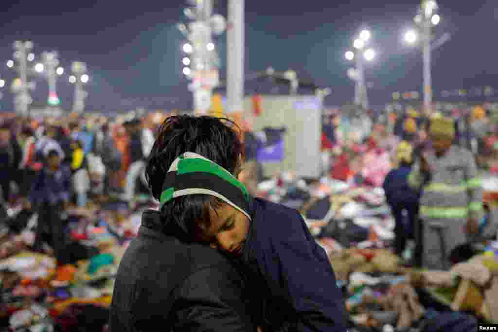 A Hindu holds his son as they leave after a deadly stampede before the second Shahi Snan (royal bath) at the Maha Kumbh Mela, or the Great Pitcher Festival, in Prayagraj, India.