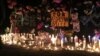 In this May 3, 2016 photo, candles burn at a makeshift memorial for Ashlynne Mike on the Navajo Nation southwest of Farmington, N.M. The FBI said Mike, was abducted after school on Monday, May 2, and her body was found the next day.