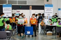 香港选举人员在为选举委员会举行投票后在点票中心交付投票箱。 （2021年9月19日）