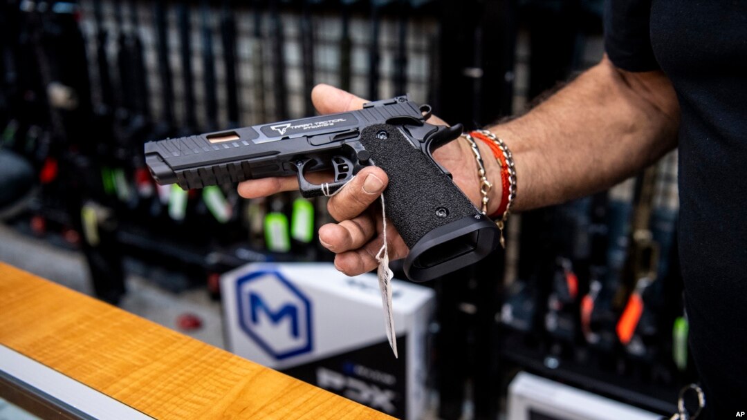Un empleado muestra una pistola en una tienda de venta de armas de fuego en Nueva York, el 23 de junio de 2022.