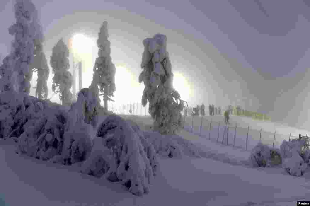 Race marshals prepare the competition hill in the fog before the first run during the FIS Alppine Ski World Cup in Levi Ski resort in Kittila, Finland.