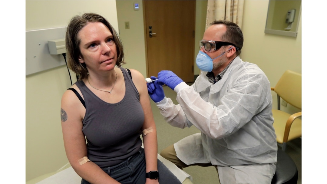 A pharmacist gives Jennifer Haller, left, the first shot in the first-stage safety study clinical trial of a potential vaccine for COVID-19 at the Kaiser Permanente Washington Health Research Institute in Seattle, Washington, March 16, 2020.