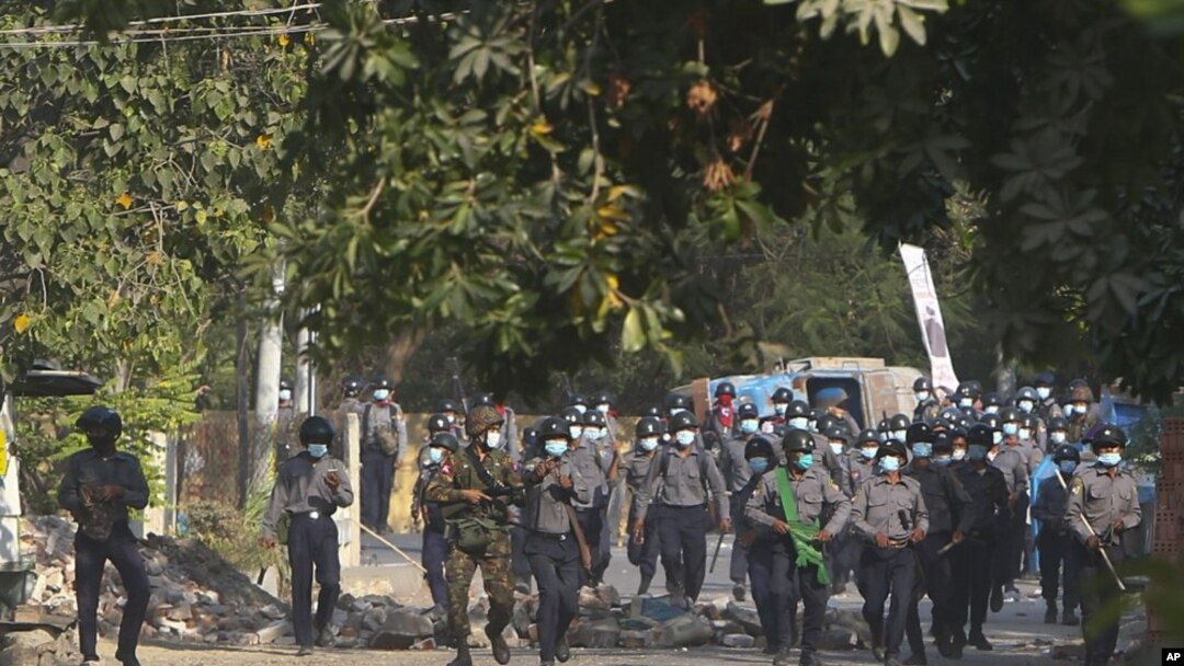 Myanmar riot police crossing a blockage during a protest against the military takeover in Mandalay, Myanmar, Sunday, Feb. 28, 2021. (AP Photo)