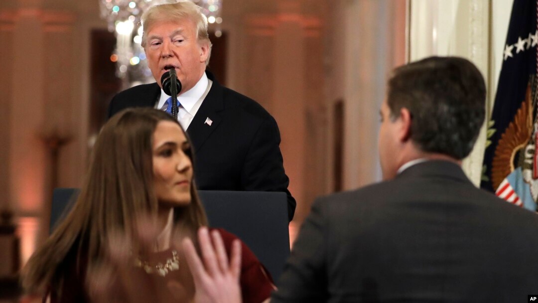 Predsednik Tramp posmatra dok pripravnica pokušava da uzme mikrofon novinaru CNN-a Džimu Akosti (Foto: AP/Evan Vucci)