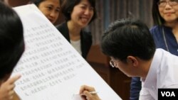 立委（蔡适应）在临时提案上签名(美国之音齐勇明拍摄)