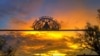 The sun sets over the gateway of peyotera Amada Cardenas's house in Mirando City, Texas. Ironwork reflects core Native American Church values of faith, hope, love and charity.