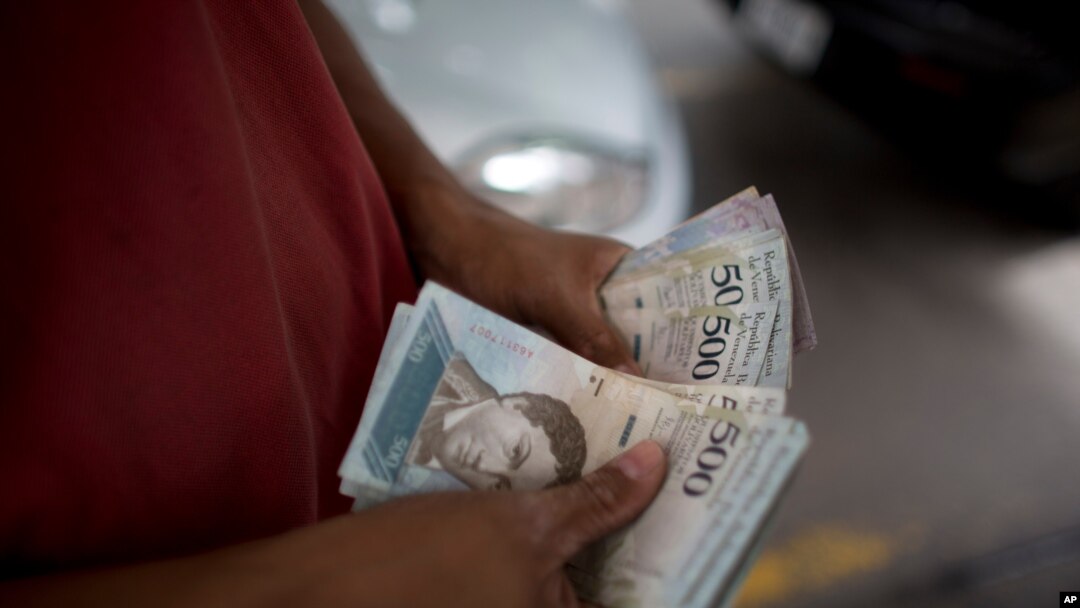 Un empleado cuenta los bolívares en una gasolinera en Caracas, Venezuela. Agosto 18, 2018. Foto: AP.