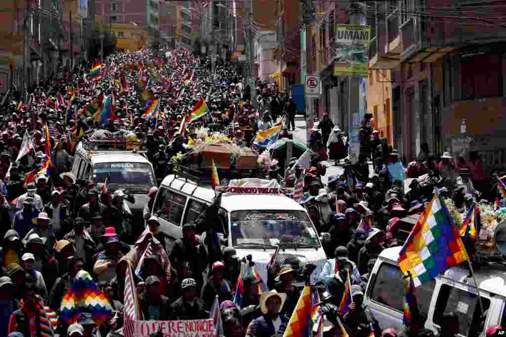 Anti-government demonstrators accompany the coffins that contain the remains of people killed in clashes between supporters of former President Evo Morales and security forces, in a funeral procession into La Paz, Bolivia.