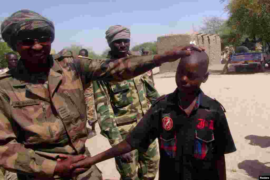 Tsoiffin 'yan kungiyar Boko Haram sun tattaru a gaban sojojin Chadi a garin Ngouboua ran 22 Afrilu, 2015. Yaran sun ce su 'yan kasar Chadi ne wadanda aka tilasta musu shiga kungiyar Boko Haram lokacin da suke karatun allo a Najeriya, amma daga baya sun kubuce suka gudu, suka mika kawunansu ga sojojin Chadi.