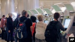 从国外归来的旅客在洛杉矶国际机场使用新型的自动护照查验机。