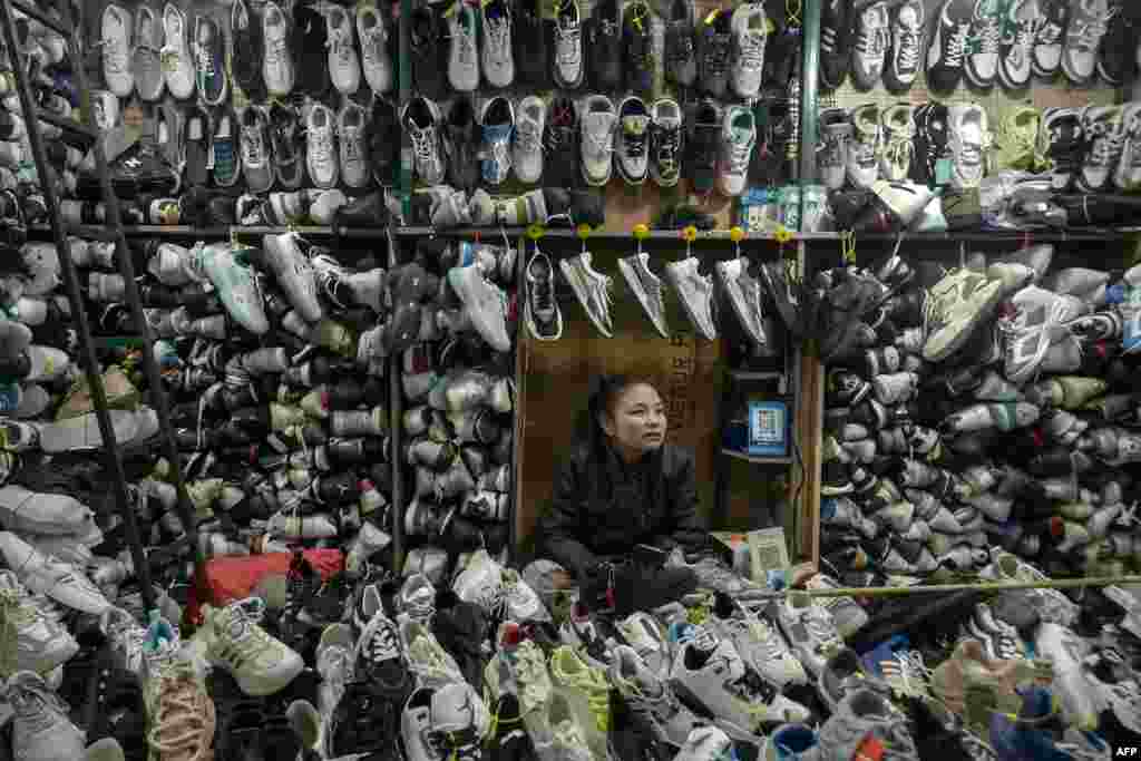 A shopkeeper selling shoes waits for customers at a market in Srinagar, Indian controlled Kashmir.