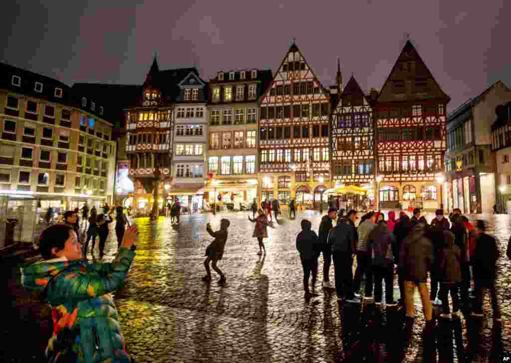 A Chinese tourist takes pictures of the Roemerberg square, the main tourist spot in Frankfurt, Germany, Nov. 17, 2019.