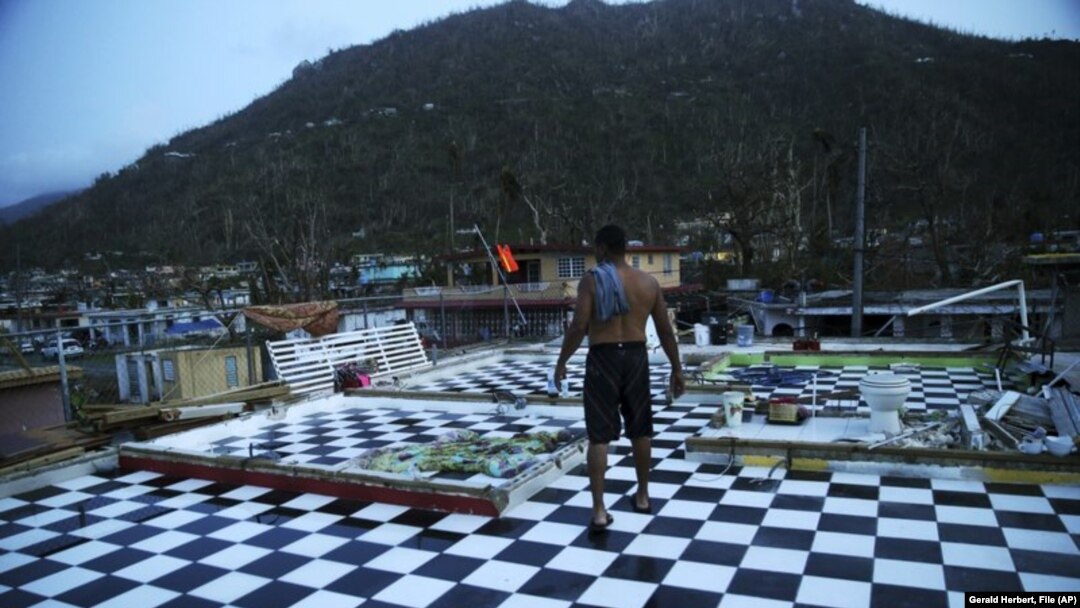 In this Sept. 26, 2017 file photo, Nestor Serrano walks on the upstairs floor of his home, where the walls were blown off, in the aftermath of Hurricane Maria, in Yabucoa, Puerto Rico.