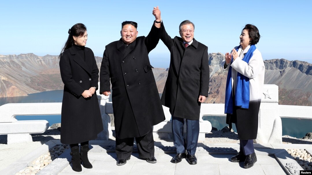 South Korean President Moon Jae-in and North Korean leader Kim Jong Un pose for photographs on the top of Mt. Paektu, North Korea, Sept. 20, 2018.