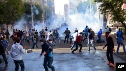 FILE - In this Oct. 7, 2014, photo, Turkish riot police use water cannons and tear gas to disperse people protesting against Turkey's policy in Syria, in Diyarbakir, Turkey.