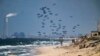 Un avión deja caer ayuda humanitaria sobre el norte de la Franja de Gaza. Foto captada desde el centro de Gaza, el lunes 25 de marzo de 2024. 