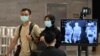 싱가포르 창이 국제공항 이용객들이 마스크를 쓴 채 발열 점검 기구를 통과하고 있다. (자료사진)