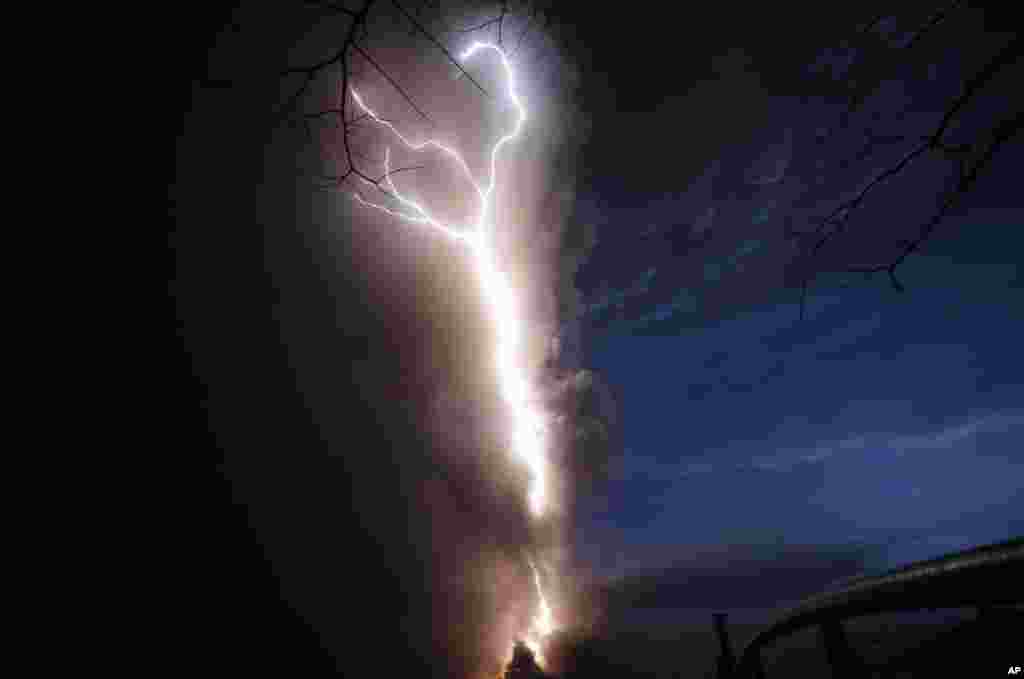 Lightning flashes as Taal Volcano erupts, Jan. 12, 2020, in Tagaytay, Cavite province, outside Manila, Philippines. A tiny volcano near the capital that draws many tourists for its picturesque setting in a lake belched steam, ash and rocks in a huge plume, prompting thousands of residents to flee and officials to temporarily suspend flights.