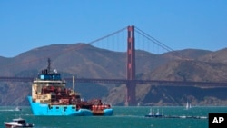 FILE - A ship tows the Ocean Cleanup Project's first buoyant trash-collecting device toward the Golden Gate Bridge in San Francisco en route to the Pacific Ocean, Sept. 8, 2018. 