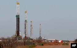 FILE - Drilling rigs dot the landscape near Calumet, Oklahoma, April 12, 2013.