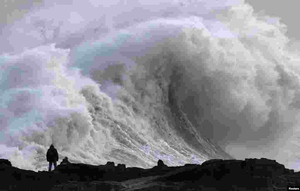 A person views large waves as Storm Eowyn arrives, in Porthcawl, Wales, Britain. REUTERS/Toby Melville